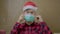 Guy in Santa hat takes off his medical mask.