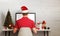 Guy with Santa`s hat work on computer with isolated display for mockup