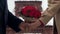 Guy showing his affection to girlfriend, presenting woman with bouquet of roses