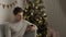 Guy sits alone at home and celebrates Christmas or new year. with phone in hands