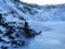 A guy sits on a bench frozen in lake kerid in the crater of an extinct vuklan. Wonders of Iceland in Winter