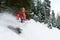 guy snowboarder rides freeride in the forest leaving behind spray of snow