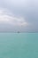 A guy is standing on a rock in the middle of the ocean. The power of the ocean