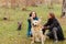 The guy is stroking the dog and the girl raised her ears in the woods for a walk