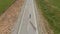 Guy in summer in black clothes descends from the mountain on a skateboard