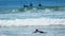 Guy swimming on surfing board in ocean diving into wave, beginner learning surf