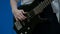 Guy teen bass guitarist playing a black electric guitar. Close-up. The fingers of a teenager are pulling strings on a bass guitar.