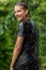 Guy teenager splashing water. Young handsome boy outdoors.