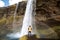 Guy tourist standing near waterfall enjoying,back view