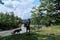 Guy is traveler and tourist. Young handsome Caucasian man with German shepherd is walking along bank of mountain river with large