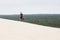 Guy walking high the Pilat dune in the sand