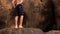 guy walks barefoot along stones around lake created by stream