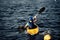 A guy wearing a helmet on a canoe polo rowing a paddle and sailing on water. canupolo. puts on a rescue yellow. water splashes