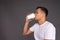 A guy in a white t-shirt greedily drinks coffee in the morning