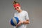 Guy in a white T-shirt, red sunglasses with a bandana and a bun on his head and with a basketball on a gray wall