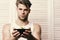 Guy in white tank top offers food. Macho with serious face holds bowl with yellow measure tape