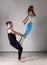 Guy and young woman doing strength exercises in yoga assanes. Acroyoga concept