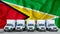 GUYANA flag in the background. Five new white trucks are parked in the parking lot. Truck, transport, freight transport. Freight