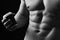 Guys abs and strong chest. Athletes body in close up, hand holding coffee cup