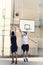 guys playing a basketball game in a urban place