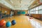 Gym With Basketball and Exercise Balls on the Floor, A school\\\'s gym filled with various sports equipment, AI Generated