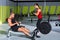 Gym couple with dumbbell weights and fitness rower