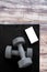 Gym dumbbells on fitness mat showing phone app. Weights on exercise yoga mat and smartphone for health progress tracking