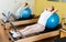 Gym girl pilates stretching sport in reformer bed with ball