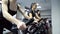 In gym three young women stand actively going on an exercise bike.