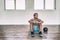 Gym workout man training floor exercises with weighted slam ball or medicine ball taking a break tired sweating thinking