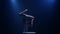 Gymnast performs acrobatics on a table in a dark studio. Smoke blue background. Slow motion