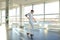 Gymnast in sportswear training near ballet barre in sport gym