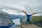 Gymnast standing on his hands on the edge with fjord on background near Trolltunga. Norway