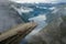 Gymnast standing on his hands on the edge with fjord on background near Trolltunga. Norway