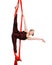 Gymnastic girl exercising on red fabric rope