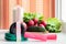 Gymnastic jump rope and vegetables for a healthy diet - tomato, cucumber, radish and lettuce are on the table near the window. On