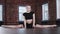 Gymnastic training - beautiful blonde young woman sitting in a horizontal split and leaning forwards - looking in a