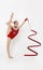 Gymnastics athlete performing beautiful dance with ribbon, white background