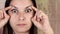 Gymnastics for a face, woman doing anti-aging exercises. Facebuilding facial exercises. Face yoga. Close-up