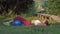 Gymnastics outdoors, young sports girl pumping press in supine position and legs locking on large fitness ball on lawn