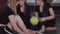 Gymnastics - three acrobatic women sitting on the floor with a ball and a hoop for gymnastics performance