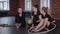 Gymnastics - three acrobatic women sitting on the floor with a ball and a hoop for gymnastics performance and talking -