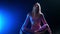 Gymnastics - young plastic attractive woman sitting in splits - blue neon lighting