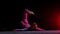 Gymnastics - young plastic woman in pink costume performing an exercise - red neon lighting