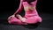Gymnastics - young woman in pink costume sits in lotus pose