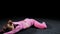 Gymnastics - young woman in pink costume sits in splits and leaning forwards