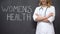 Gynecologist standing near inscription Womens health, infertility treatment