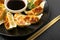 Gyoza Chinese Dumplings on Black Plate, Fried Vegetable Jiaozi Macro, Chicken Momo Pile, Asian Gyoza Closeup