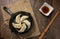 Gyozas, fried japanese dumplings on cast-iron pan served with soy sauce.