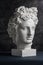 Gypsum copy of ancient statue Apollo head on dark textured background. Plaster sculpture man face.